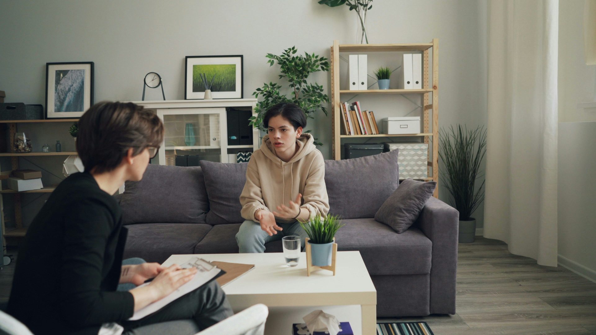 two people sitting on a couch in a living room